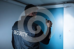 Male Security Guard Standing In Front Of Door