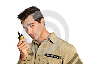 Male security guard in uniform using portable radio transmitter on background
