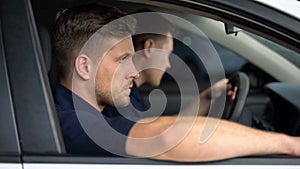 Male security guards sitting in car, monitoring safety, private investigators