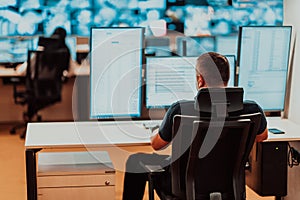 Male security operator working in a data system control room offices Technical Operator Working at workstation with