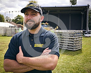 Male Security Team Member Outdoors As Stage For Music Festival Or Concert Is Set Up