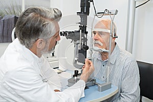 male senior in eye clinic examine eyes