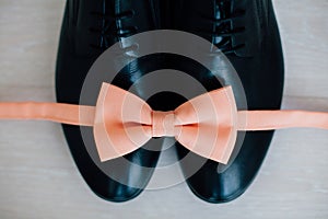 Male shoes and pink bow tie