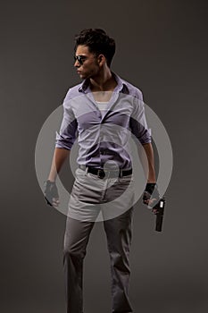 Male shooter with gun on grey background
