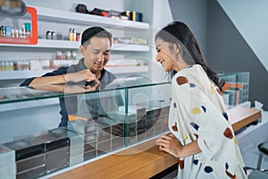 male shopkeeper pointing on the vape mods inside the display table