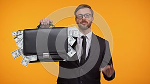 Male showing briefcase with money and doing ok gesture, payday lending service