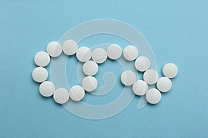 Male sign with bent arrow of white pills symbolizing potency problems on light blue background, flat lay