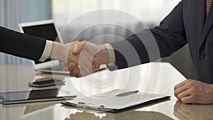 Male signing business agreement, shaking hands with partner, partnership, deal