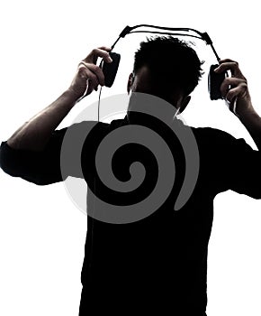 Male in silhouette putting headphones