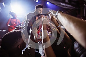 Male singer performing amidst crowd at nightclub