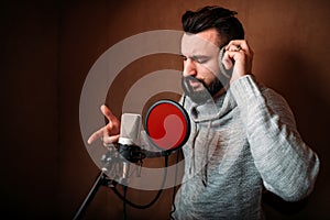 Male singer recording a song in music studio