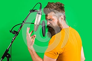 Male singer in recording studio. Bearded man sing in microphone. Karaoke. Studio records. Sings a song.