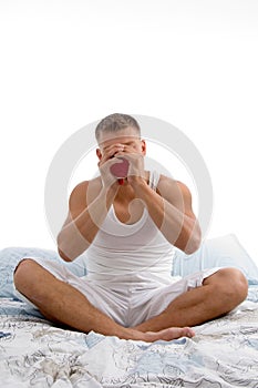 Male sipping coffee while sitting in bed