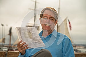 Male sitting on a bench with court papers in his hadn