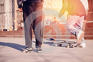 Male skateboarder guy is holding skateboard sunset. Concept active rest extreme sport