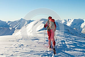 Male ski tourer enjoying the view on a summit in the alps