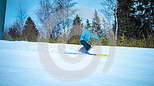 Male skier carving down the slope kicking up snow