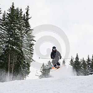 Male skier doing tricks with ski poles.