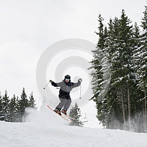 Male skier doing tricks with ski poles.