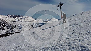 Male skier dressed in black, man skiing down a mountain piste or slope on fresh snow