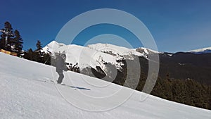 Male skier dressed in black, man skiing down a tree lined snowy mountain piste or slope on fresh snow