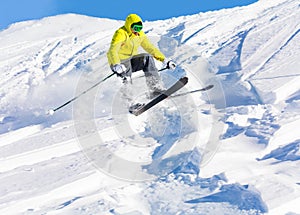 Male skier launching of mogul hitting the slopes