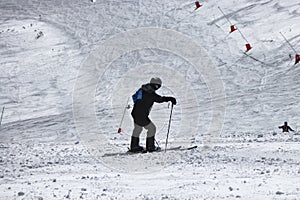 Male skier resting after skiing. A boy standing in the middle of downhill and enjoy view to valley on Chopok, Slovakia. Black and