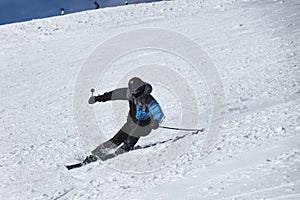 A male skier skiing downhill in Chopok, Slovakia. Carve position. Turn left. Freeride. Dificult position. Black and grey jacket.