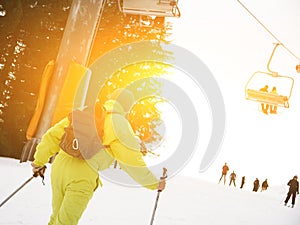 Male skier skiing downhill at ski resort against ski-lift