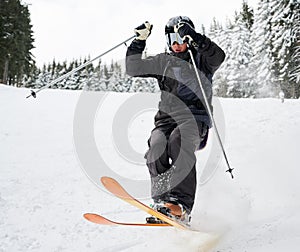 Male skier sliding down snow-covered slopes on skis.