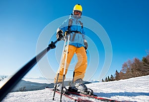 Male skier using selfie stick taking photos while skiing