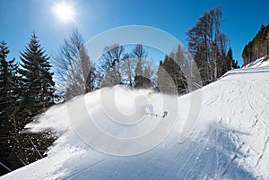 Male skier using selfie stick taking photos while skiing