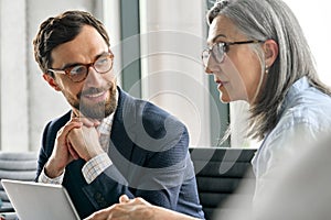 Male smiling executive manager listening to female ceo mentor leader at office.