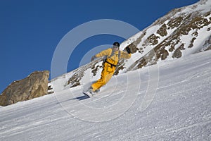 Male on snowboard on the slope of mountain