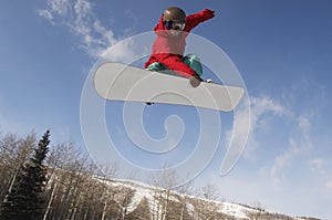 Male Snowboarder Jumping Against Sky