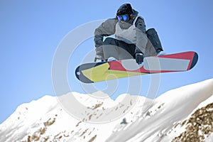 Male snowboarder jumping with snowboard