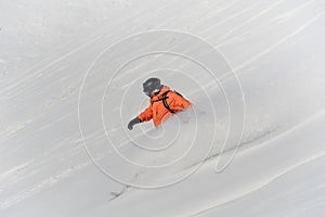 Male snowboarder riding down the snow slope