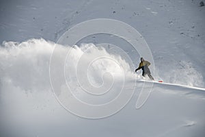 Male snowboarder slides on a snowboard in distance