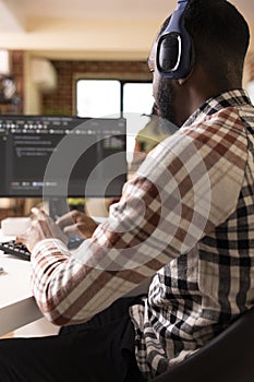 Male software developer with headphones coding from home