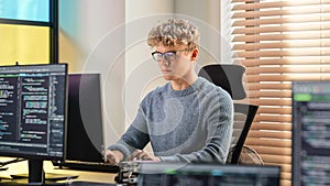 Male Software Engineer Coding On Desktop Computer in Creative Office Space. Young Caucasian Man