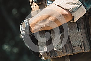 Male soldier wearing a bulletproof vest and a shirt with short sleeves.