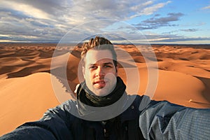 Male solo traveler taking selfie in Sahara desert, Morocco.