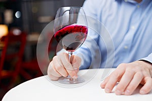 Male sommelier is checking and testing red wine