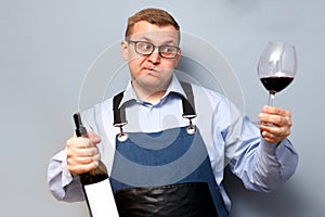 Male sommelier is checking and testing red wine