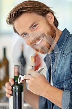 male sommelier open wine bottle with corkscrew