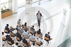 Male speaker with digital tablet speaks in a business seminar