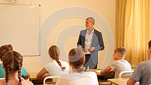 Male speaker giving lesson for teenage students in classroom