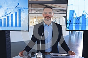 Male speaker looking at camera while standing at podium in business seminar