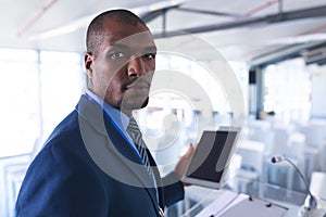 Male speaker practicing his speech on digital tablet in business seminar