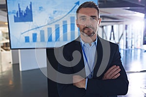 Male speaker standing with arms crossed in business seminar